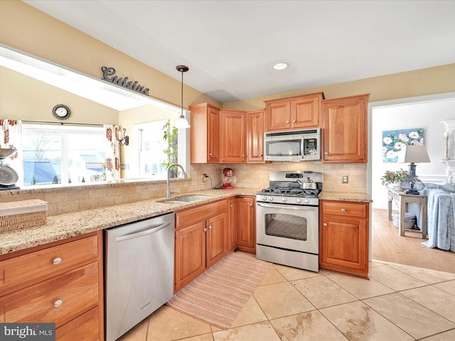 kitchen featuring stainless steel appliances, decorative backsplash, light tile patterned flooring, a sink, and light stone countertops