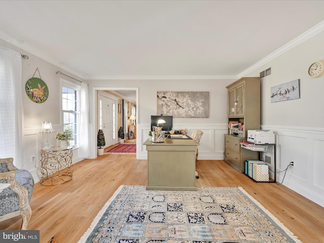 office area featuring visible vents, ornamental molding, wainscoting, and light wood-style flooring