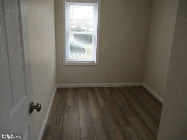 unfurnished room with dark wood-type flooring