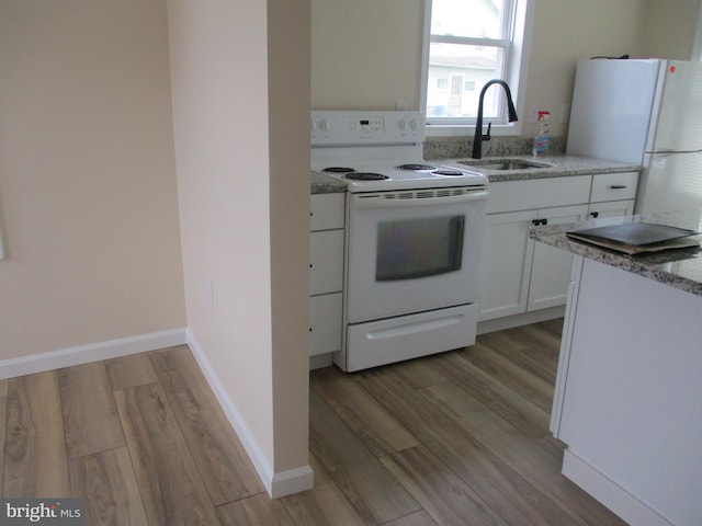 kitchen featuring sink, white appliances, white cabinets, and light wood-type flooring