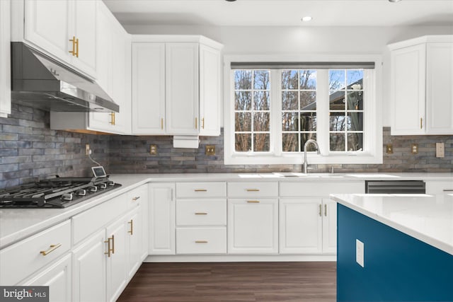 kitchen with tasteful backsplash, dark wood-type flooring, light stone countertops, stainless steel gas stovetop, and white cabinetry