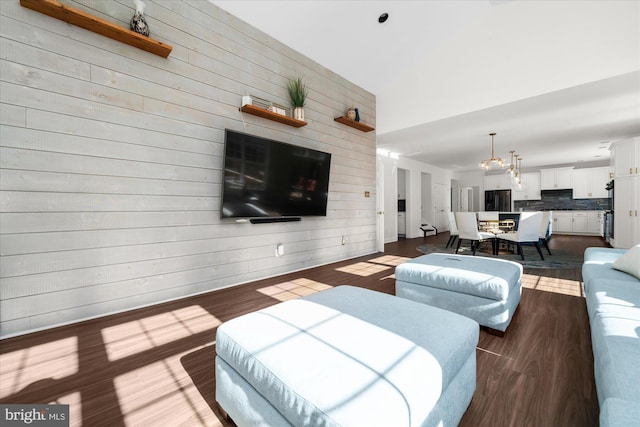 living room featuring dark hardwood / wood-style flooring, wooden walls, and lofted ceiling