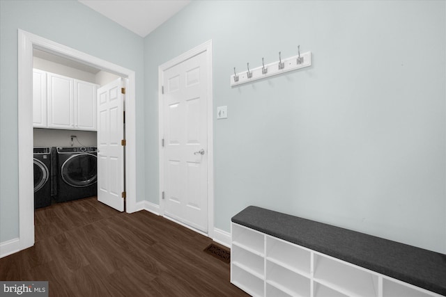 washroom featuring cabinets, washing machine and clothes dryer, and dark hardwood / wood-style floors