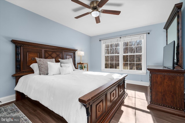 bedroom with dark hardwood / wood-style flooring and ceiling fan