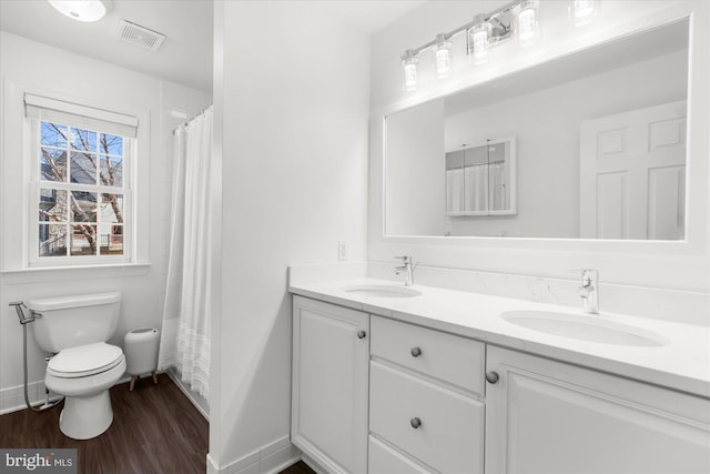 bathroom with hardwood / wood-style floors, vanity, a shower with shower curtain, and toilet