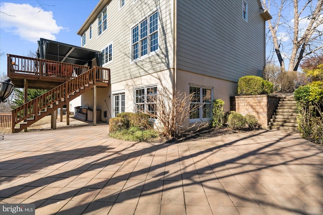 view of home's exterior with a patio and a wooden deck