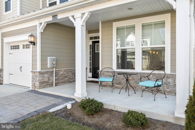 doorway to property with covered porch and a garage