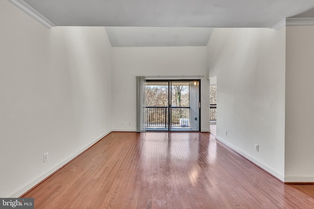 spare room featuring baseboards and wood finished floors