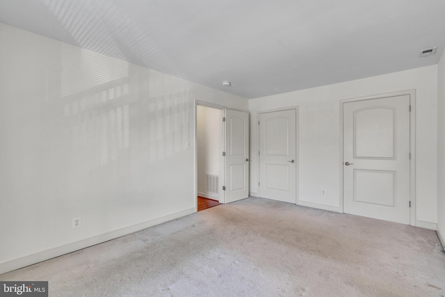 unfurnished bedroom featuring carpet flooring, baseboards, and visible vents