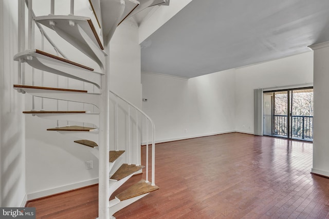 stairway featuring ornamental molding, baseboards, and hardwood / wood-style floors