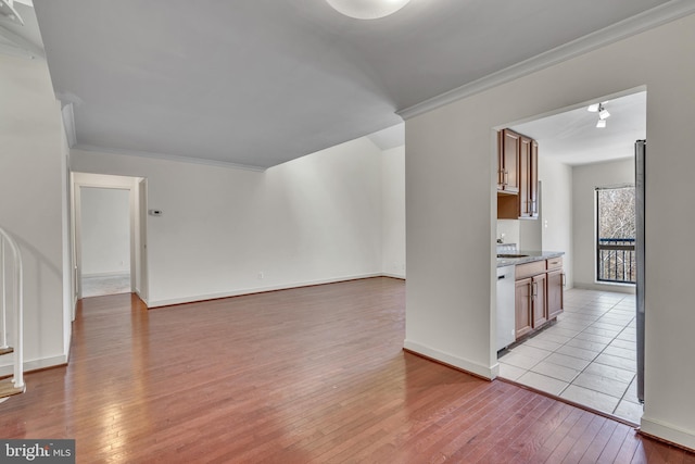 interior space featuring light wood-type flooring, baseboards, and ornamental molding