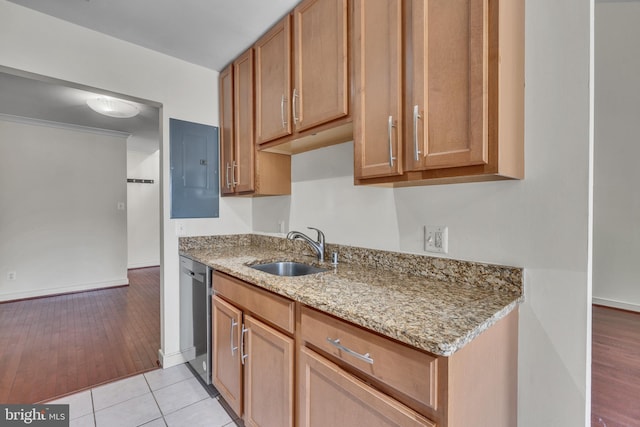 kitchen featuring a sink, electric panel, light stone counters, light wood-style floors, and stainless steel dishwasher