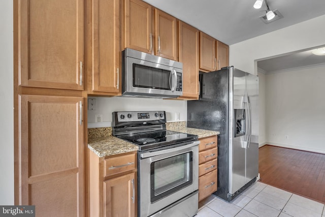 kitchen featuring visible vents, light stone counters, appliances with stainless steel finishes, crown molding, and light tile patterned floors