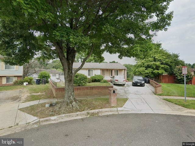 view of front facade featuring fence, a front lawn, and driveway