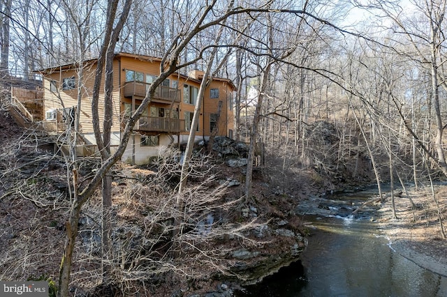 rear view of property with a chimney and a balcony