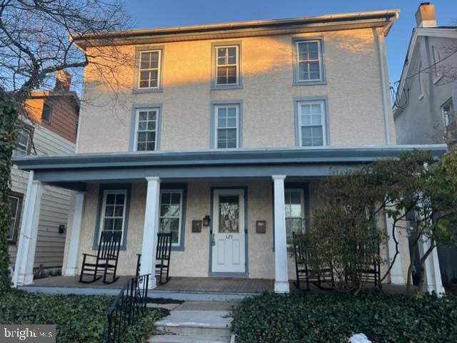 view of front of house featuring covered porch and stucco siding