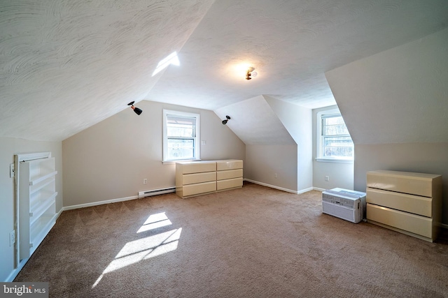 bonus room featuring plenty of natural light, a textured ceiling, a baseboard heating unit, and vaulted ceiling