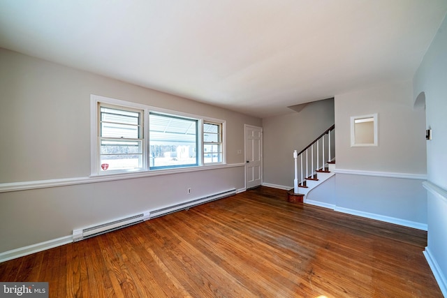 interior space with wood finished floors, stairs, baseboards, and a baseboard radiator