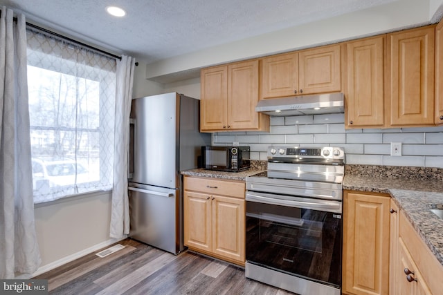 kitchen with under cabinet range hood, stainless steel appliances, plenty of natural light, and visible vents