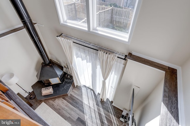 staircase featuring a wood stove and wood finished floors