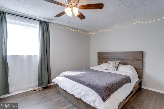 bedroom with baseboards, a textured ceiling, a ceiling fan, and wood finished floors