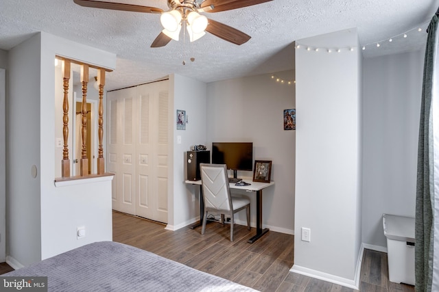 bedroom featuring baseboards, wood finished floors, a closet, a textured ceiling, and a ceiling fan