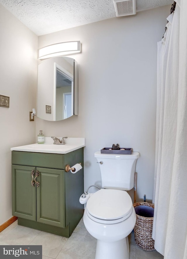 bathroom with visible vents, toilet, vanity, tile patterned floors, and a textured ceiling