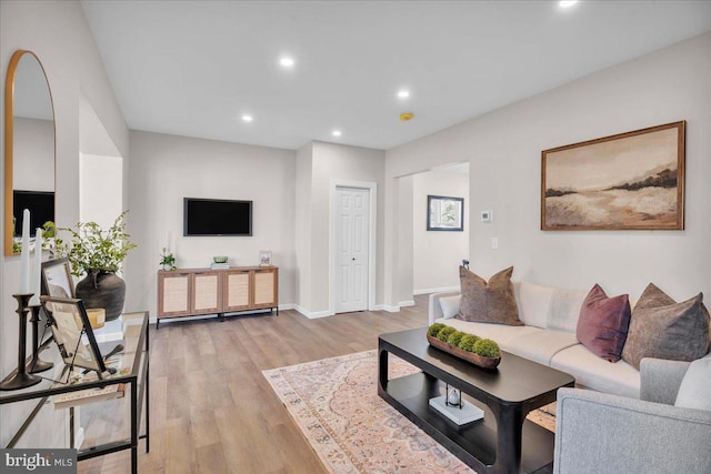 living area with light wood-style floors, recessed lighting, and baseboards