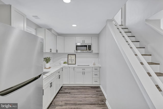 kitchen featuring white cabinetry, stainless steel appliances, and light hardwood / wood-style flooring