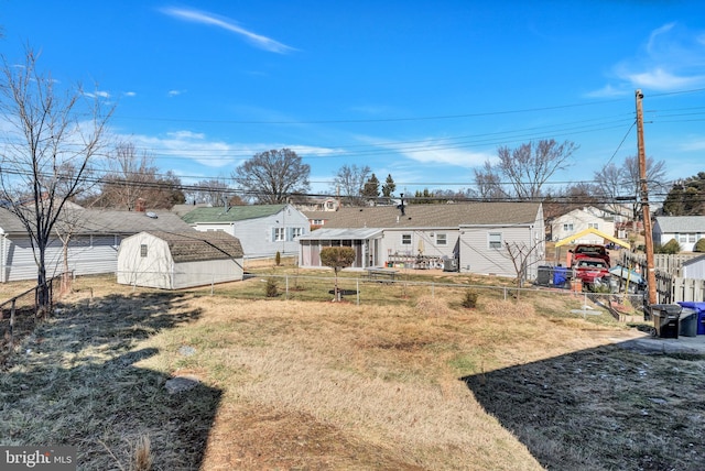 back of property featuring a yard and a storage shed