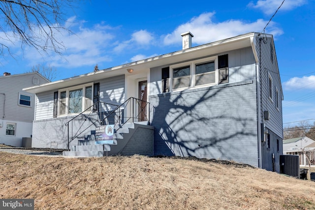 view of front of property featuring central AC and a front lawn