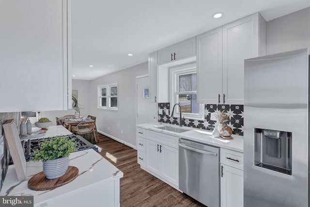 kitchen featuring sink, appliances with stainless steel finishes, white cabinetry, and tasteful backsplash