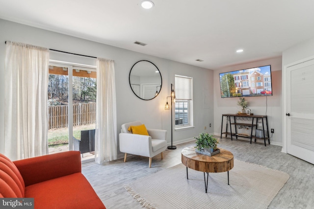 living area featuring recessed lighting, baseboards, visible vents, and light wood-style floors