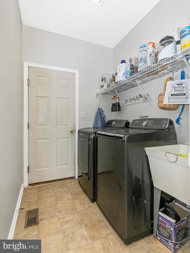 laundry area with laundry area, a sink, visible vents, baseboards, and washer and dryer