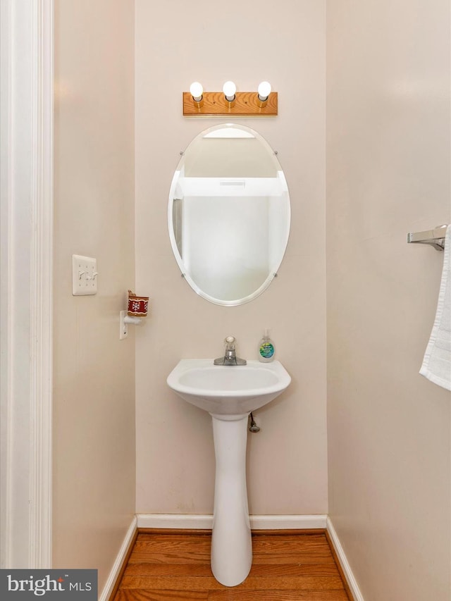 bathroom with wood finished floors and baseboards