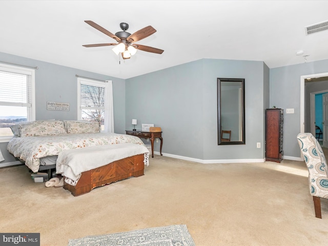 bedroom with baseboards, visible vents, and light colored carpet