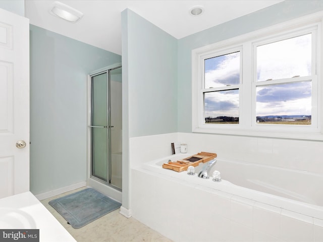 bathroom featuring a stall shower and a bath