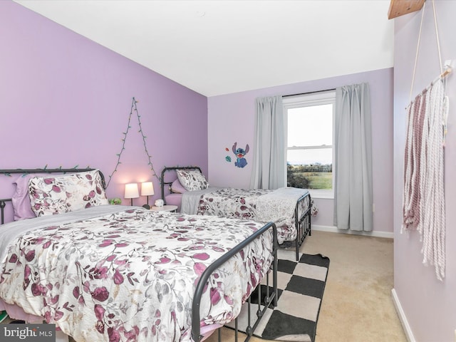 bedroom with baseboards and light colored carpet