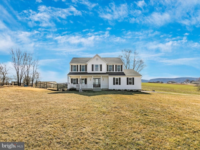 view of front of house with covered porch, a front lawn, and fence