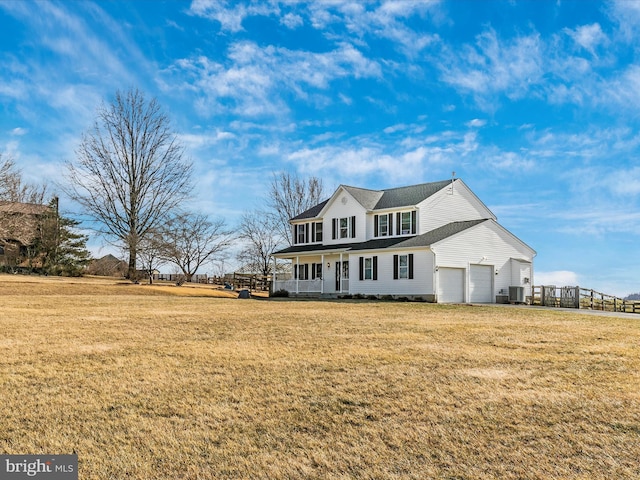 view of front of property featuring a garage, covered porch, and a front lawn