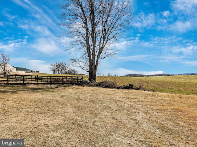 view of yard featuring a rural view and fence