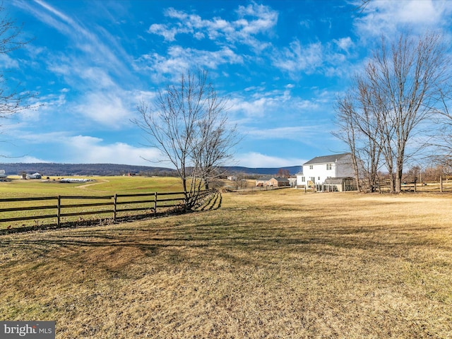 view of yard featuring a rural view and fence