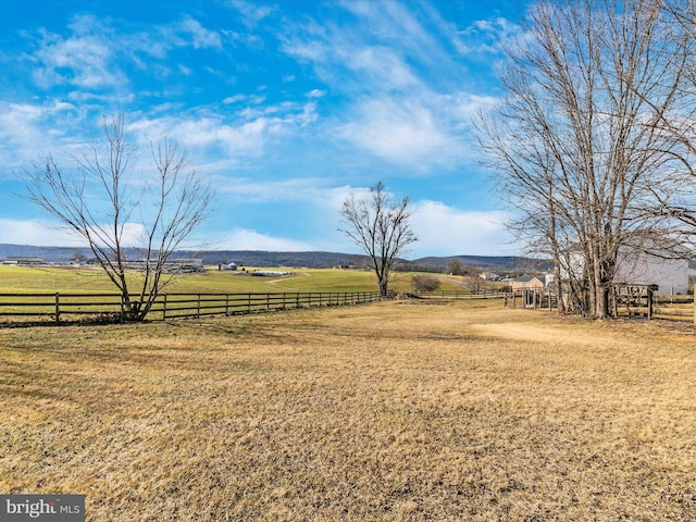 view of yard featuring a rural view and fence