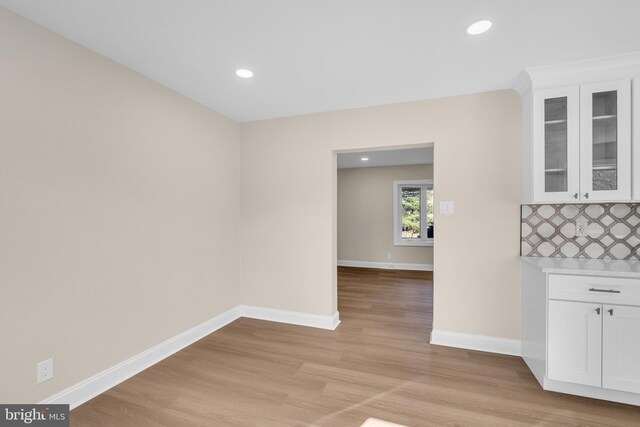 unfurnished dining area with light wood finished floors, baseboards, and recessed lighting