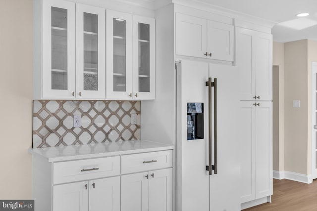 kitchen featuring white cabinets, glass insert cabinets, light countertops, and high end white fridge