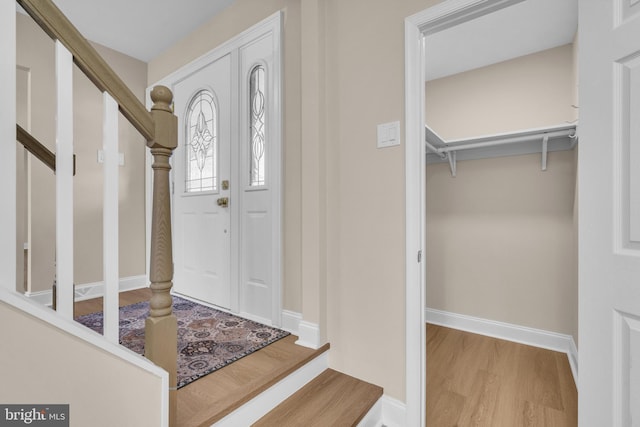 entryway featuring stairs, wood finished floors, and baseboards