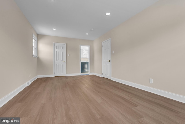 spare room featuring recessed lighting, wood finished floors, and baseboards