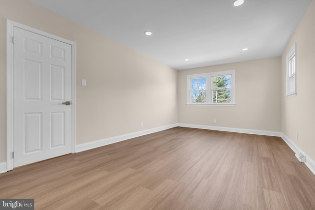 spare room featuring recessed lighting, wood finished floors, and baseboards