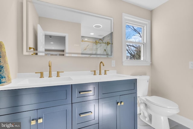 bathroom featuring toilet, double vanity, a shower, and a sink