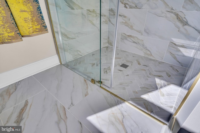 bathroom with a marble finish shower